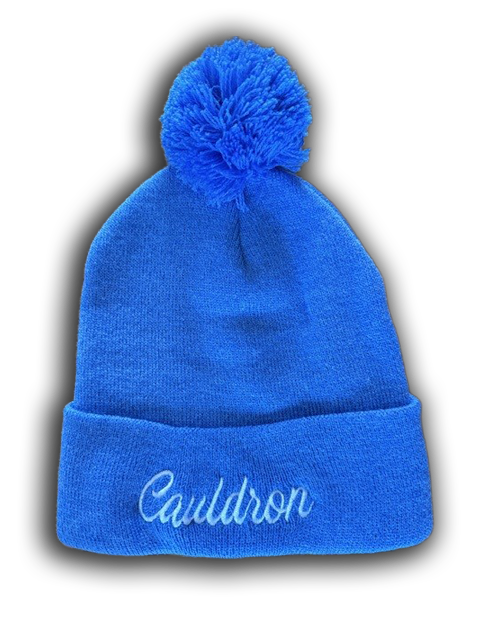 Light blue beanie with pom-pom and 'Cauldron' script embroidery