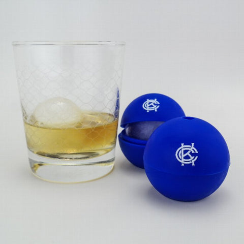 Two blue ice ball makers with the Cauldron logo, alongside a glass of whiskey with one ice ball inside.